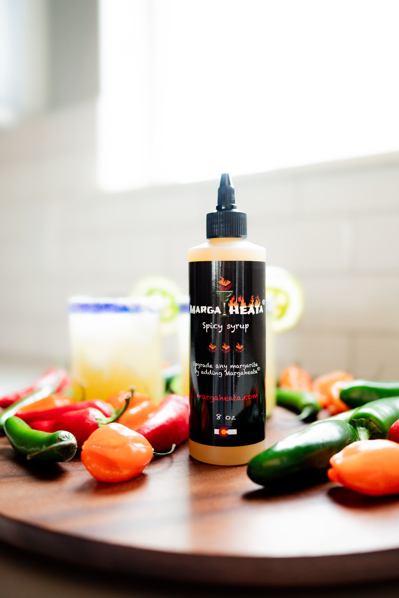 Margaheata® Swicy Syrup bottle with fresh peppers